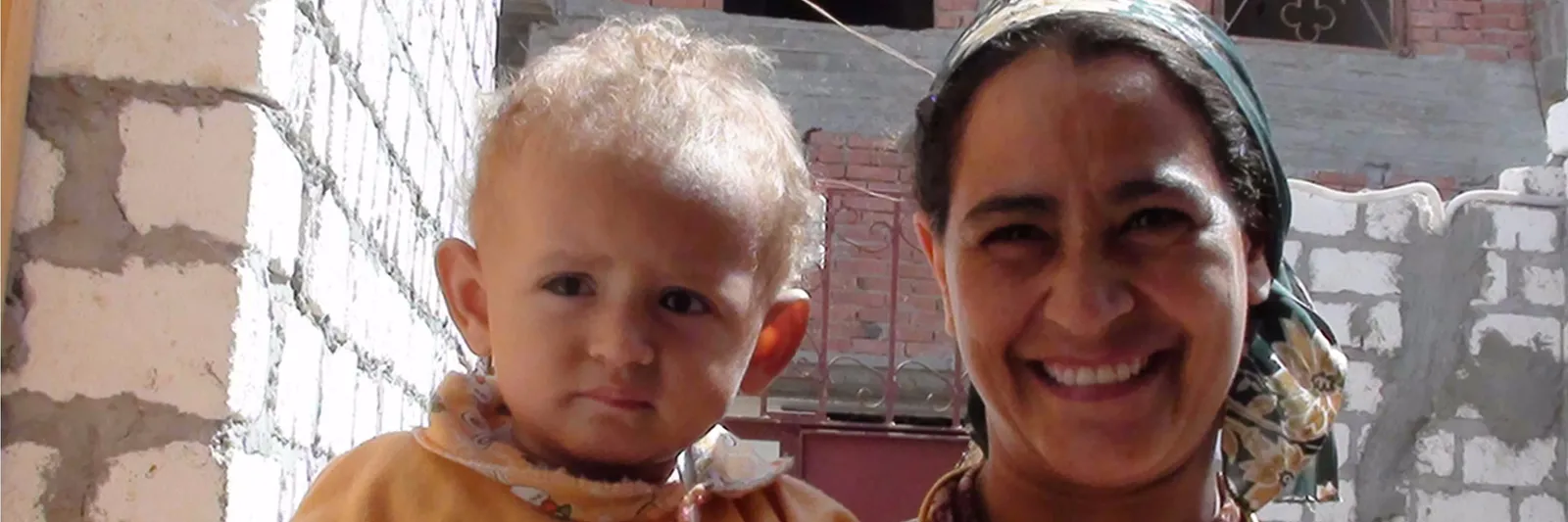 A mum with her children upon receiving their new house from Copts in Need